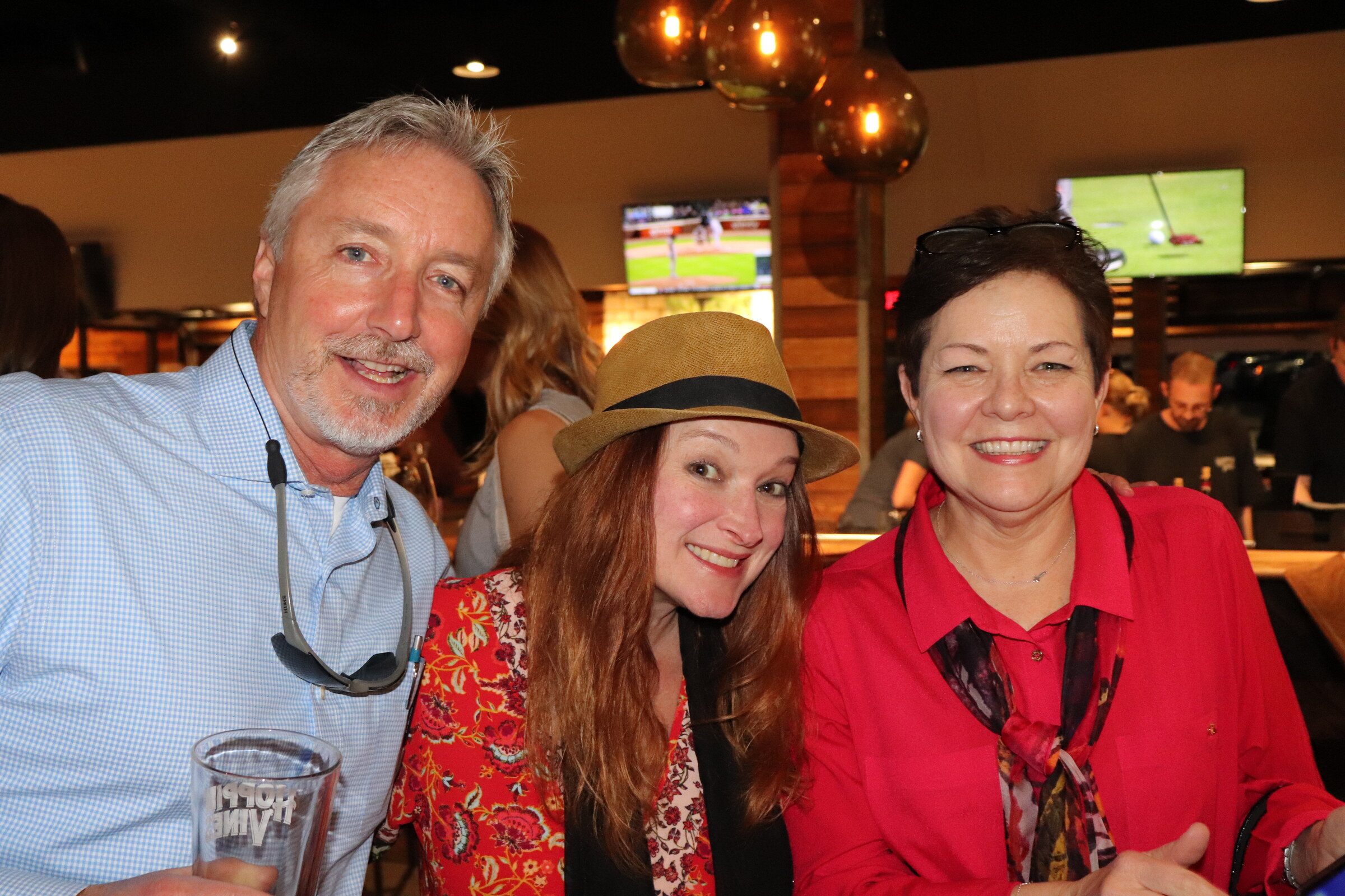 Guests smiling and enjoying drinks at the bar